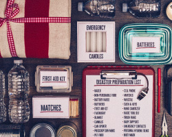 A clipboard with an emergency preparedness checklist surrounded by neatly laid out supplies